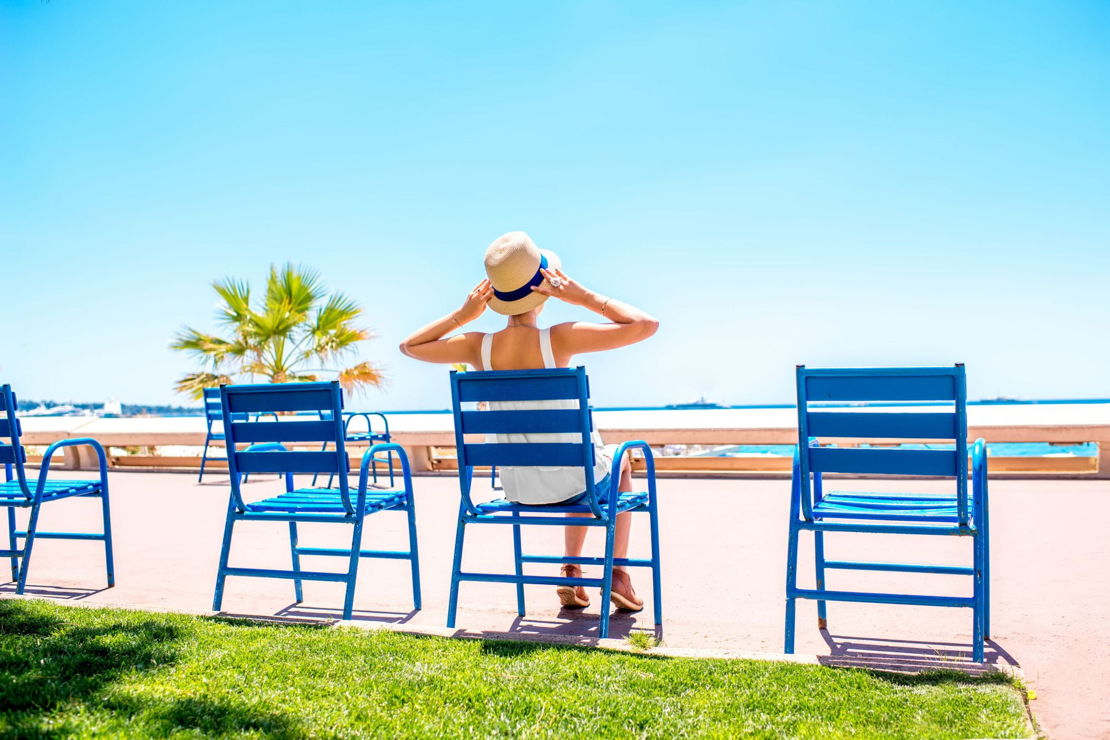 Woman,Sitting,On,The,Blue,Chairs,Of,The,Promenade,In